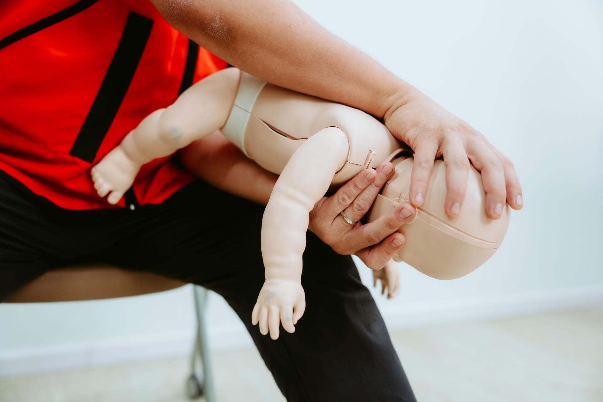 Facilitator demonstrating how to respond to infant choking using a manikin.