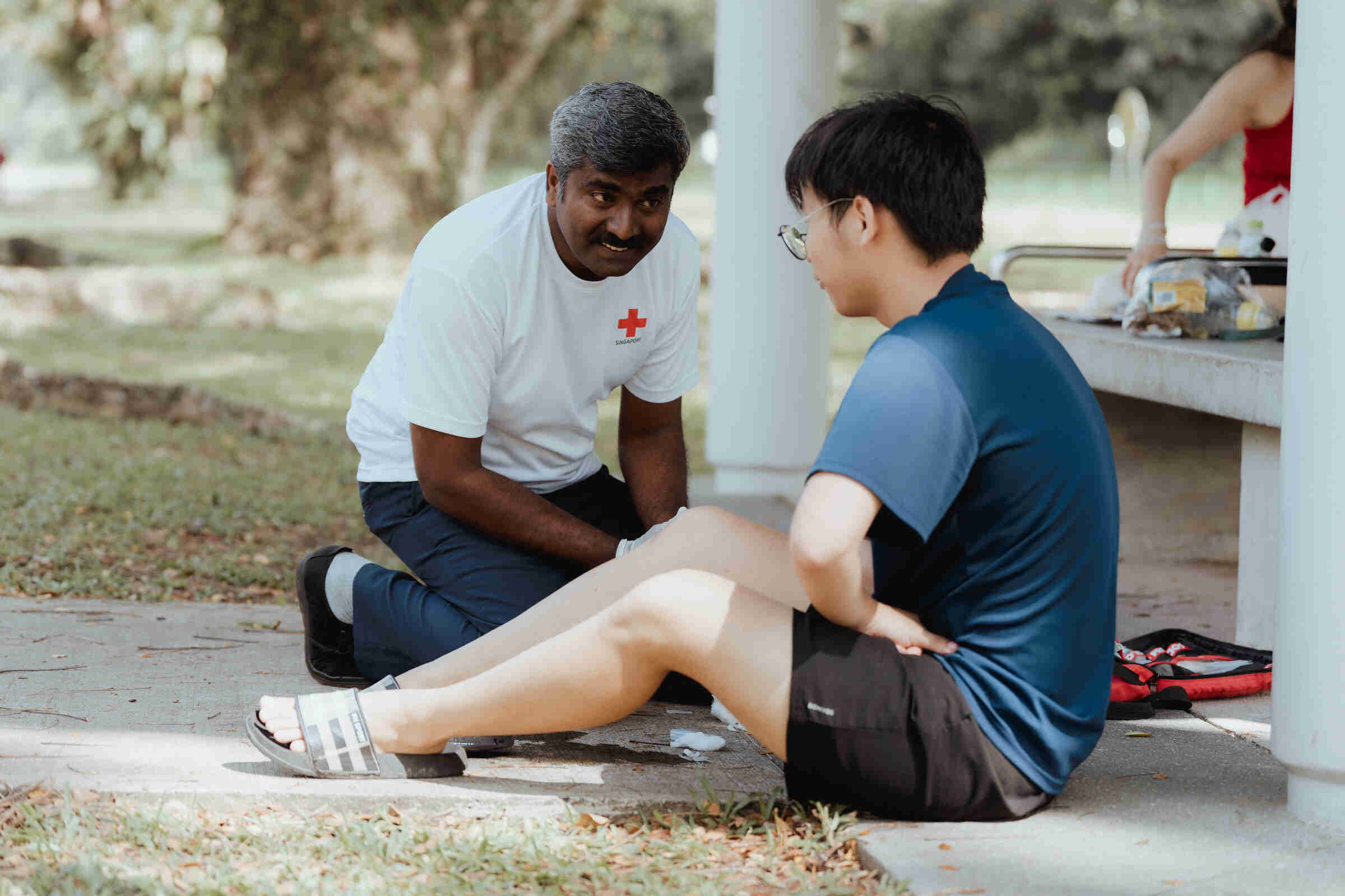 A First Aider on Wheels attending to an injured civilian at the park