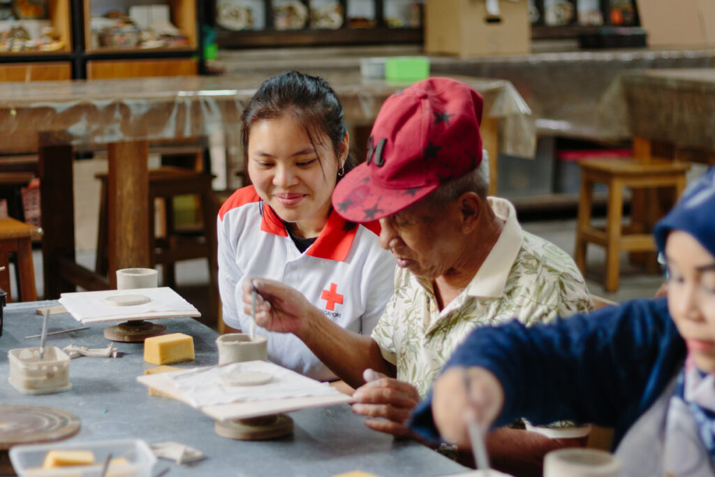 Singapore Red Cross volunteer engaging with an elderly during a CBP outing