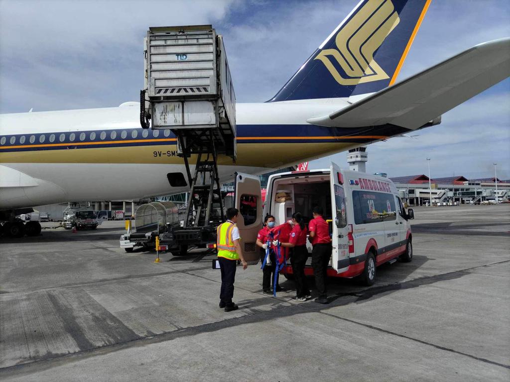 Staff assisting an injured migrant worker onto the vehicle during transportation.